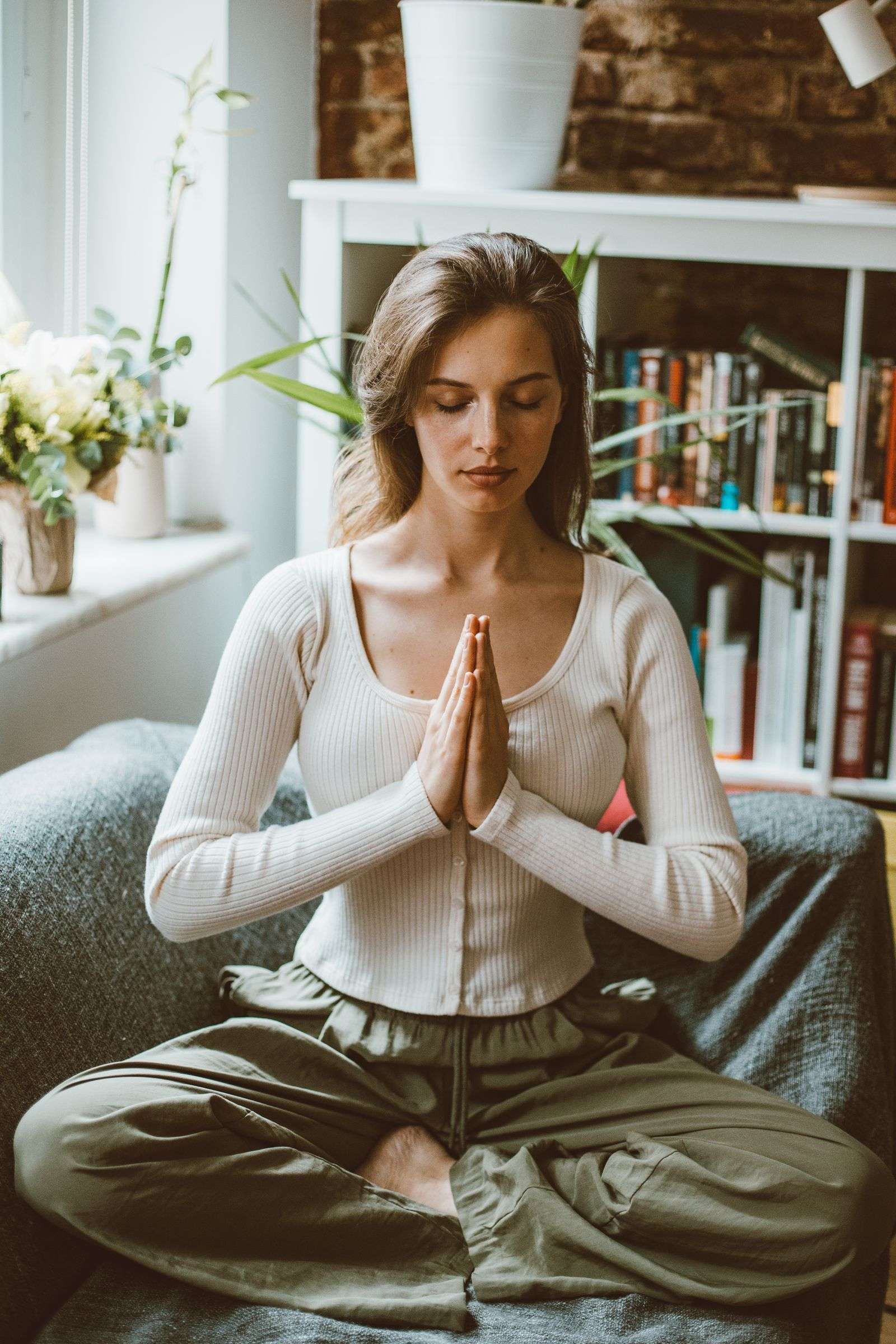 Woman meditating at home to relieve stress, a natural complement to ashwagandha benefits for cortisol