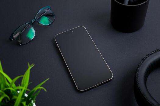 Close-up of blue light filtering glasses resting on a desk next to a smartphone