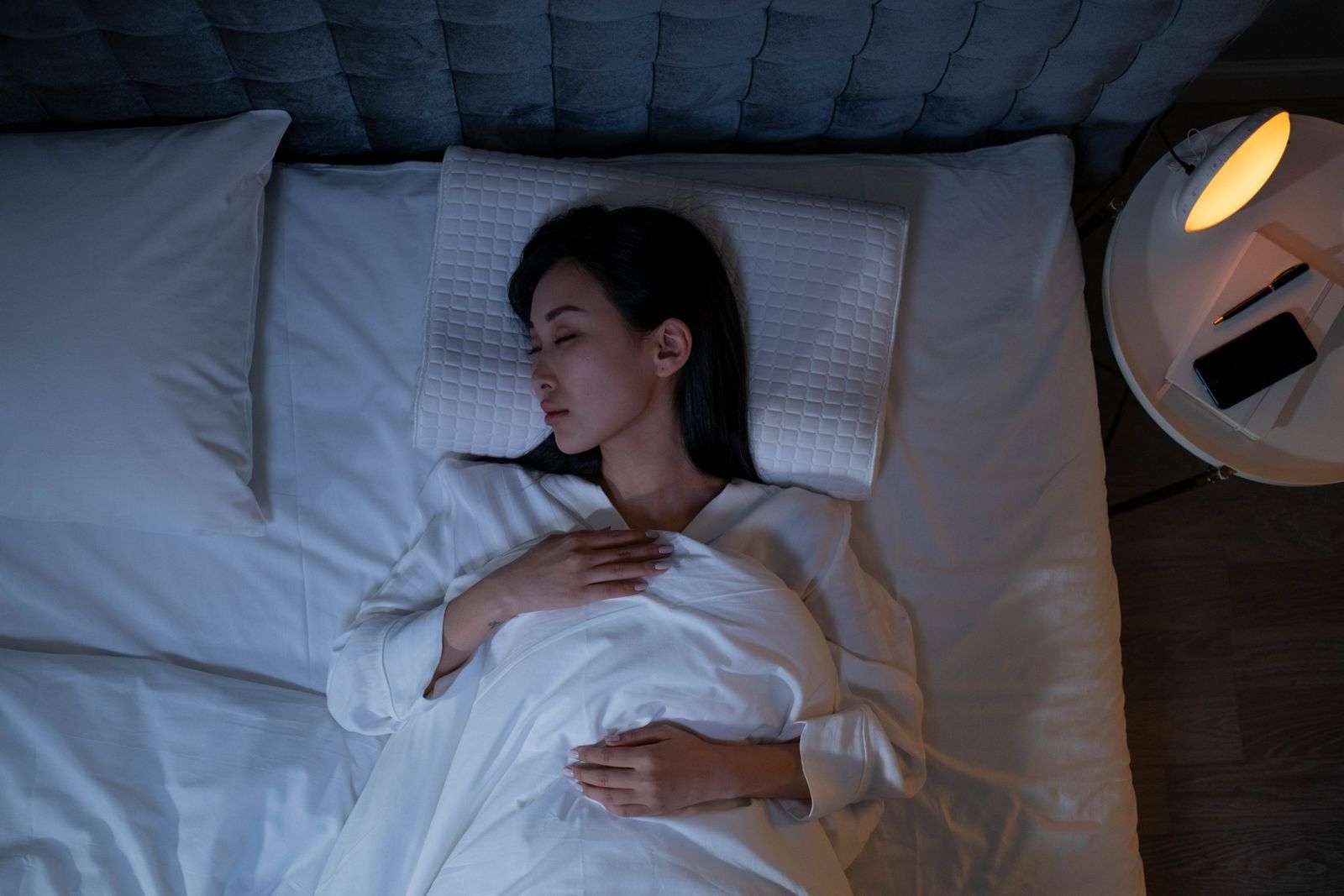 A dark, cool bedroom set up to help you fall asleep fast