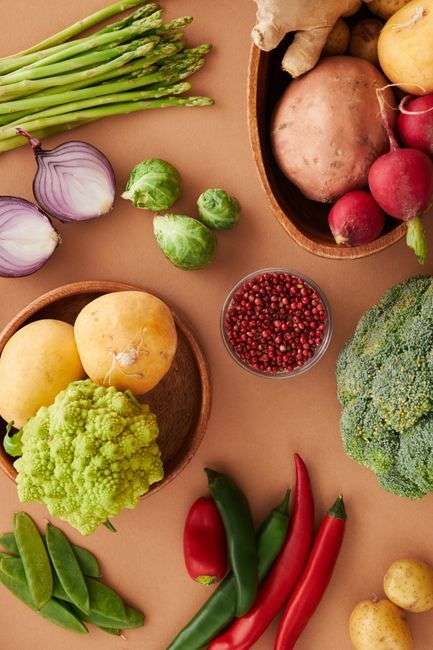 Colorful heart-healthy foods including leafy greens, vegetables, and legumes arranged on a table, supporting how to lower blood pressure naturally