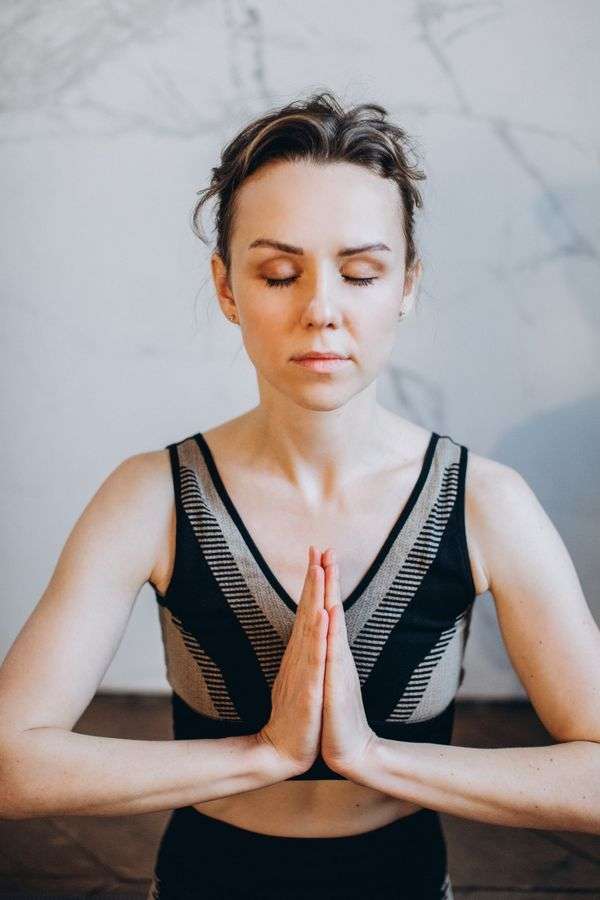 Woman meditating with slow breathing to lower cortisol naturally