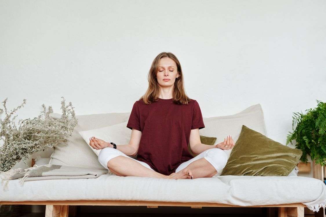 Woman practicing breathwork meditation in lotus pose, a natural way to calm the nervous system and lower resting heart rate.