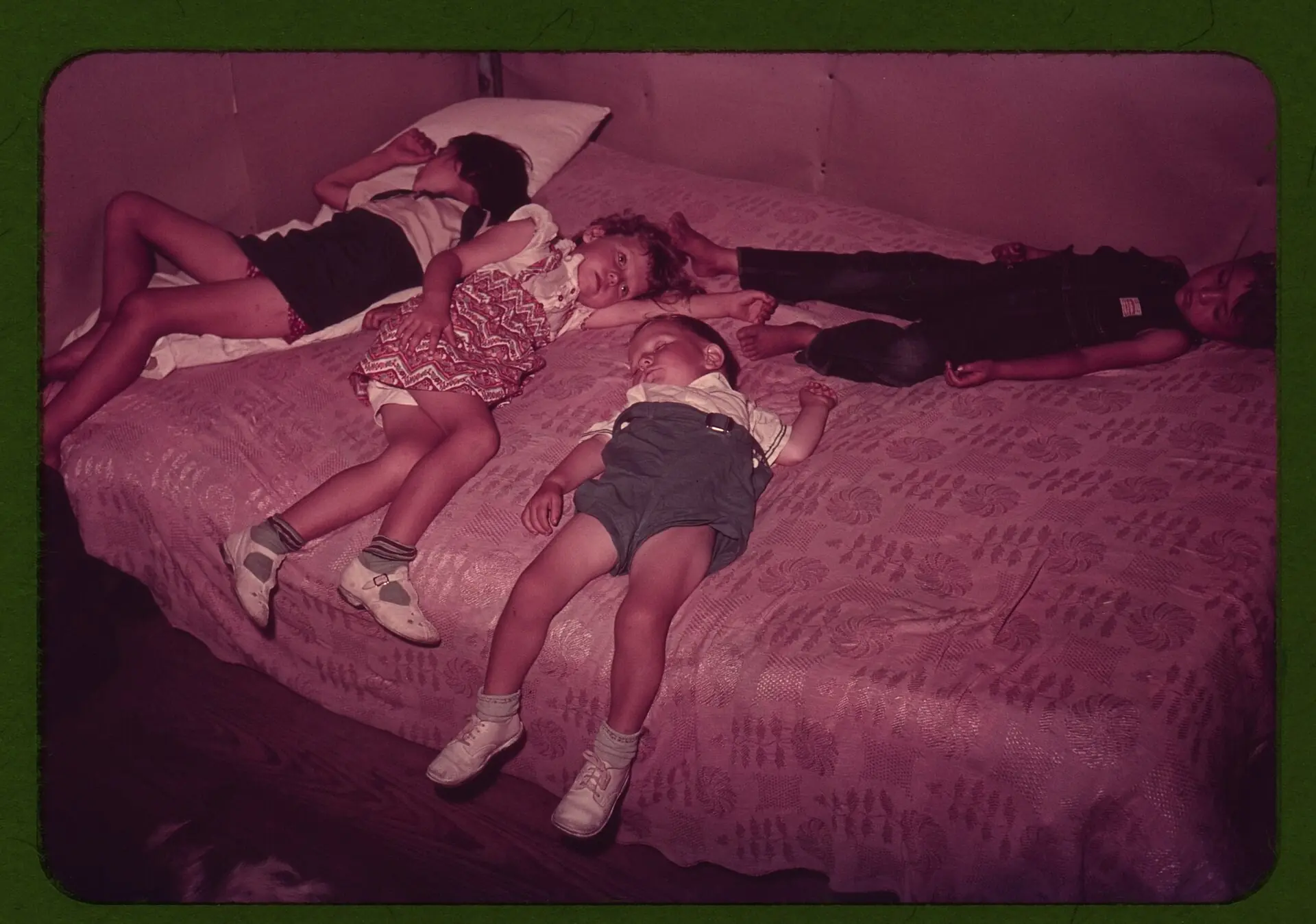 Archival photograph of children asleep on a bed
