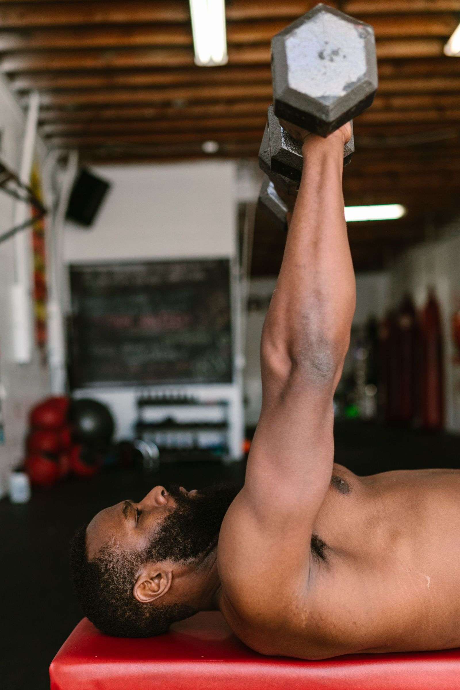 Man lifting a dumbbell with focused form during strength training after 40