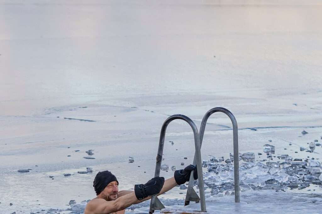 Man taking a cold plunge ice bath, one of the stress-based practices discussed by top biohackers
