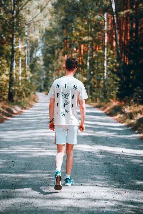 Man walking on a tree-lined road, an easy way to get walking after eating benefits