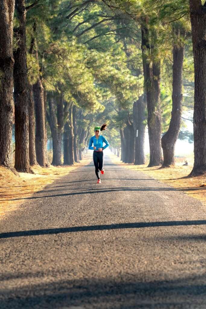 Person jogging outdoors at a steady zone 2 cardio pace, able to hold a conversation